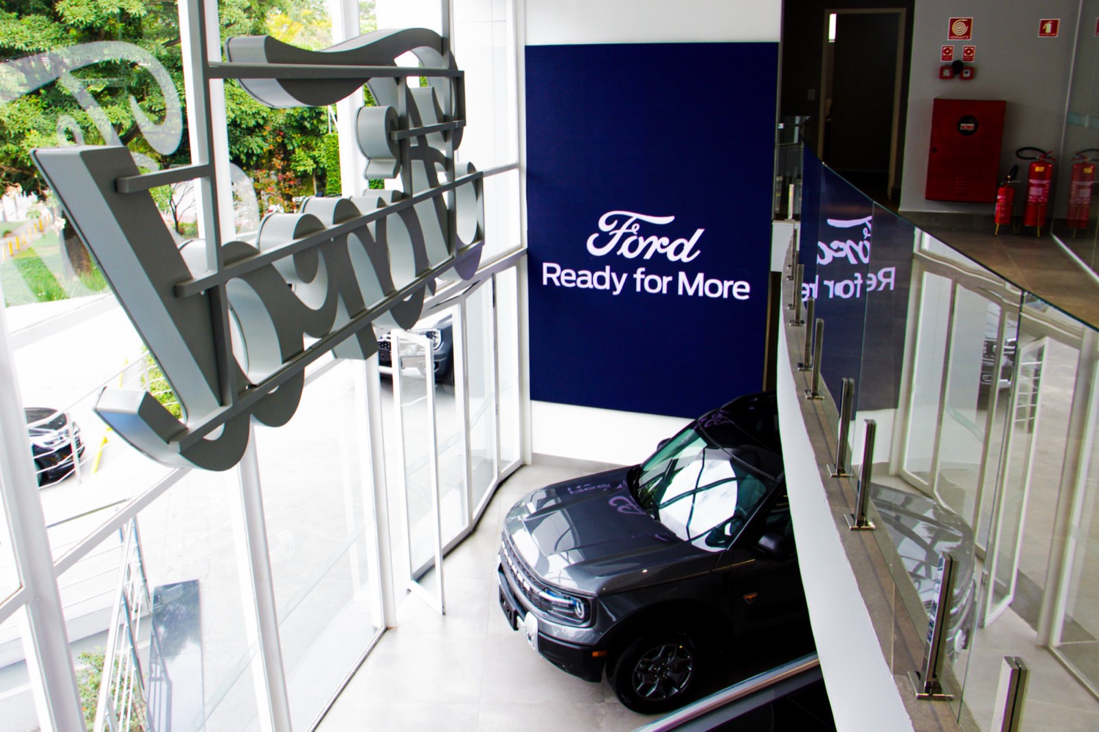 Painel de LED indoor com a mensagem Ford Ready for More ao lado de um Ford Bronco Sport no showroom