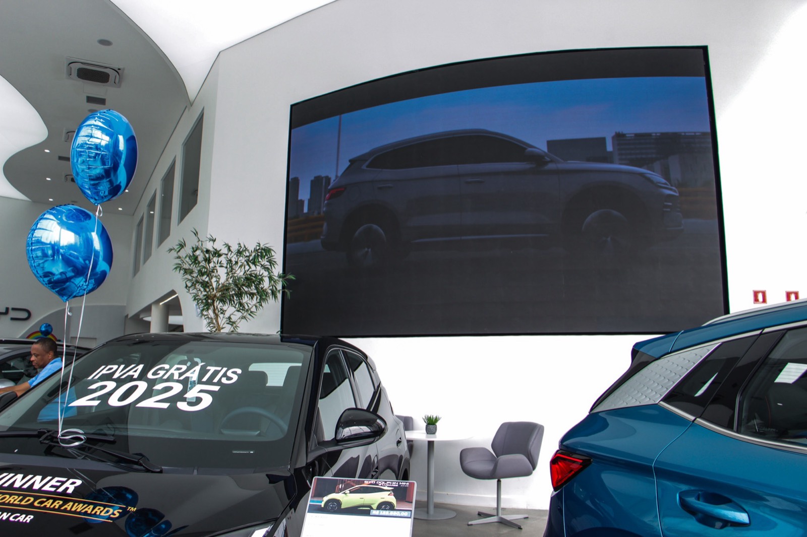 Painel de LED indoor curvo no showroom da BYD da Av. Pacaembu, exibindo a imagem de um SUV