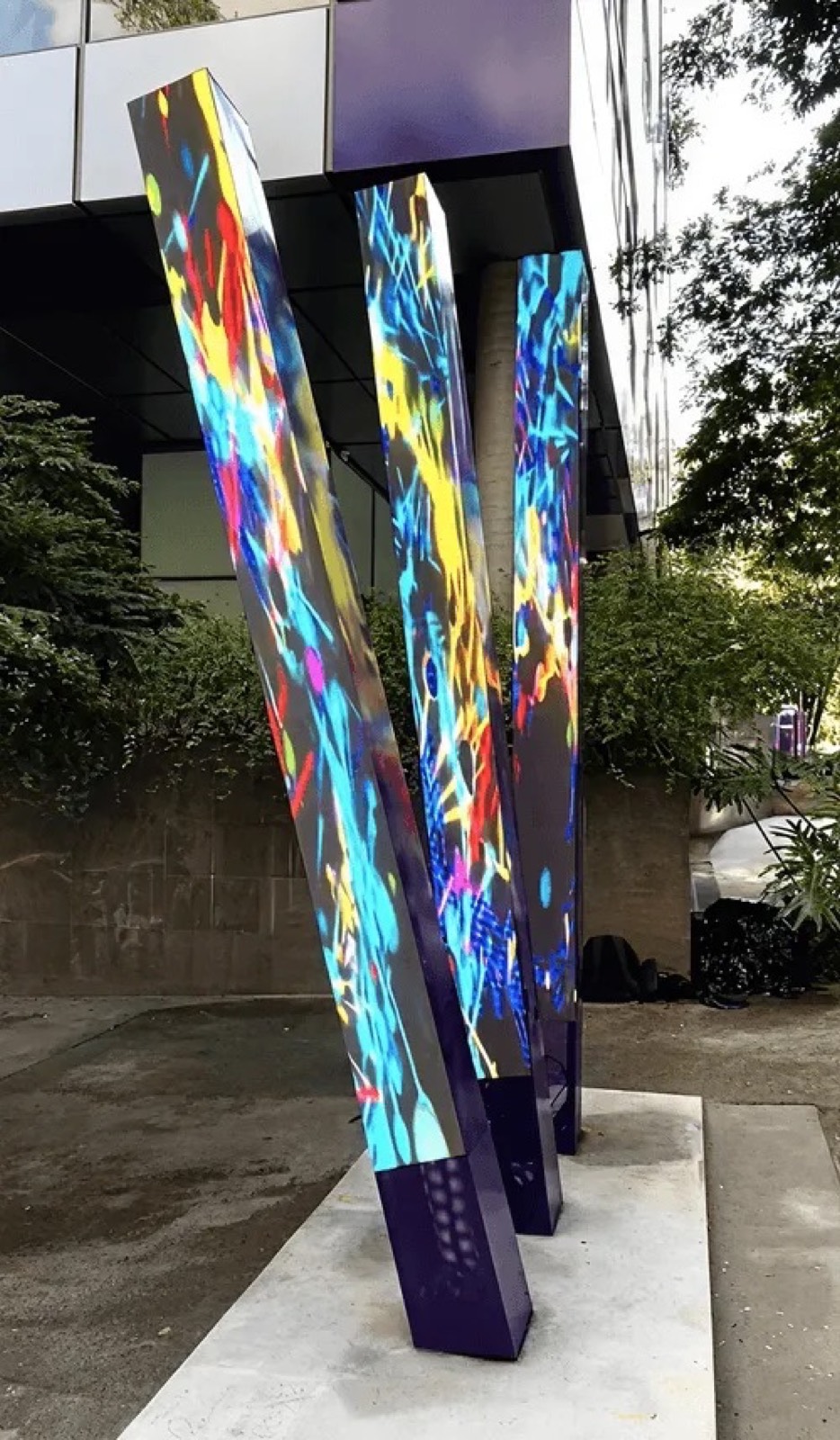 Totem LED outdoor colorido entre árvores, em área externa